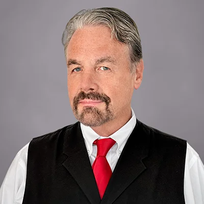 A headshot of Gary McCarver, Director of Financial Planning at SEIA, wearing a white button-down shirt, red tie, and black vest.