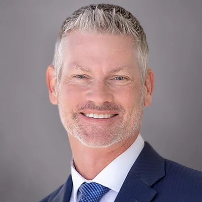 A headshot of Matt Matrisian, President of SEIA, wearing a blue suit and a white shirt with a dark and light blue tie.