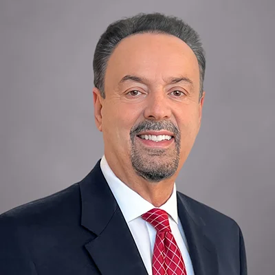 A headshot of Tony Amaradio, Managing Senior Partner at SEIA, wearing a navy blue suit, white button-down shirt, and red tie with diagonal stripes.